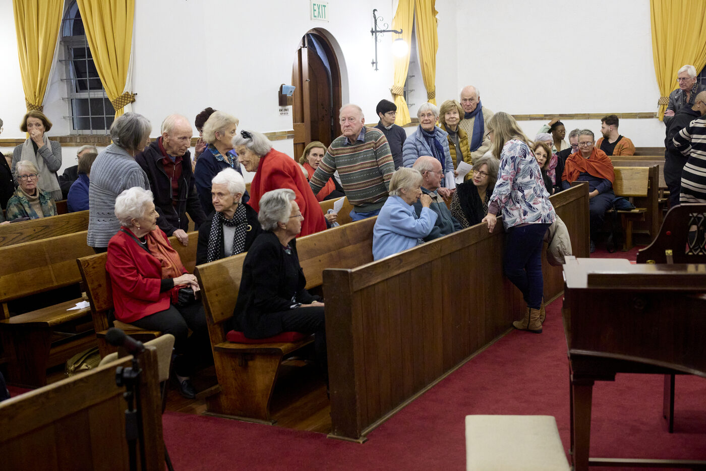 Die kerk vol mense wat mekaar groet