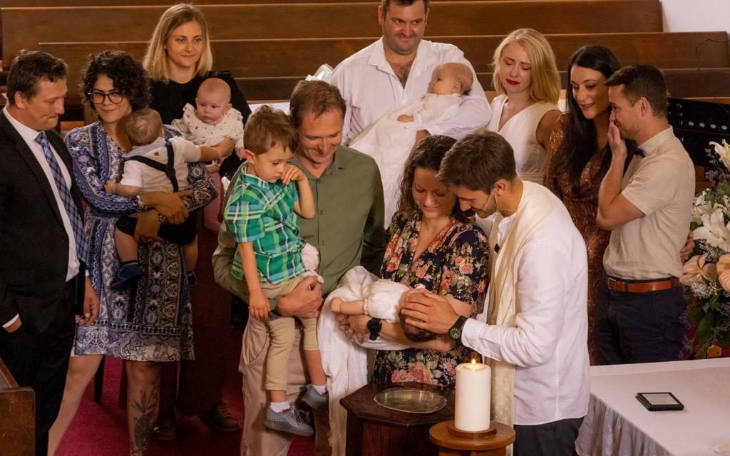 Gesinne by die doopvont tydens 'n doopdiens